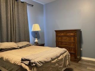 bedroom featuring wood finished floors and baseboards