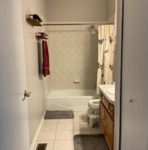 bathroom featuring visible vents, toilet, shower / tub combo, vanity, and tile patterned floors