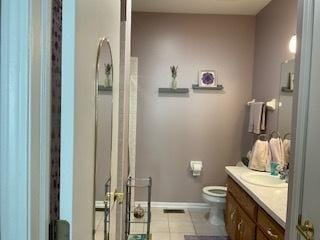 bathroom with baseboards, vanity, toilet, and tile patterned floors