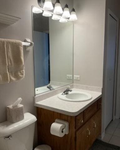 bathroom featuring toilet, an inviting chandelier, tile patterned flooring, and vanity