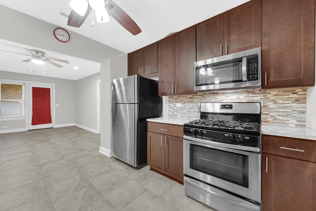 kitchen featuring stainless steel appliances, backsplash, dark brown cabinetry, ceiling fan, and baseboards