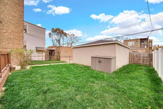 view of yard with an outbuilding, a storage shed, and a fenced backyard