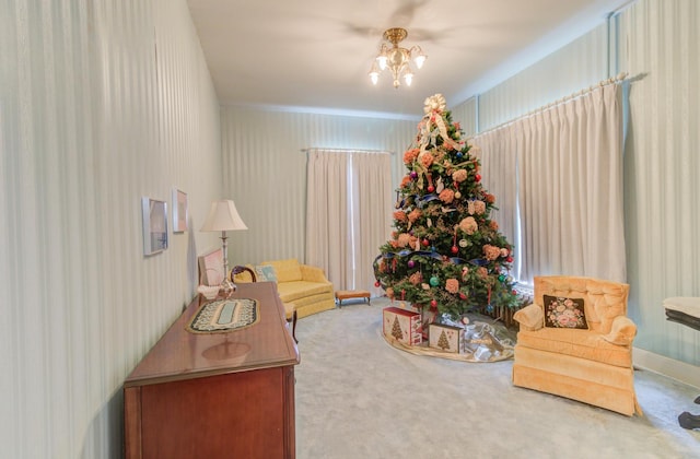 carpeted living area featuring a chandelier