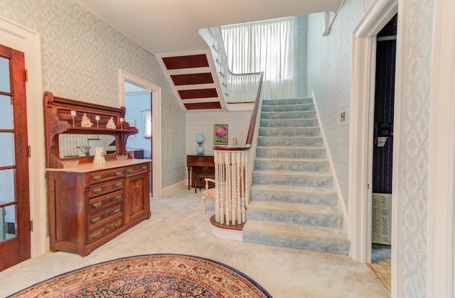 staircase with wallpapered walls, carpet, and baseboards