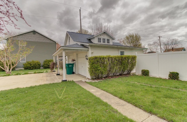 bungalow-style house with a garage, a front yard, driveway, and fence