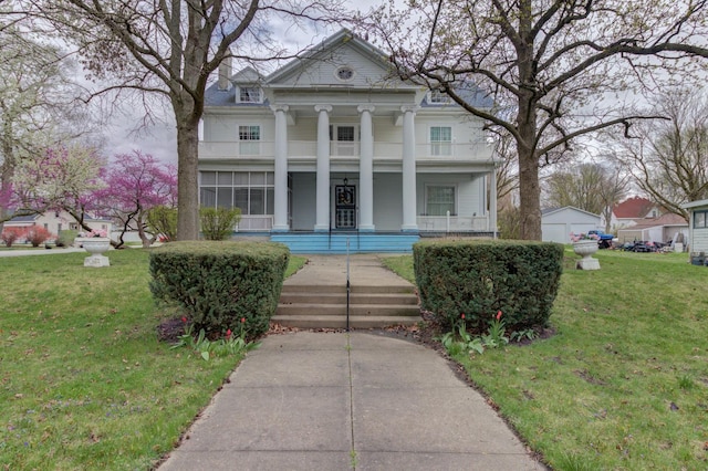 neoclassical / greek revival house featuring a porch, a front lawn, and a balcony