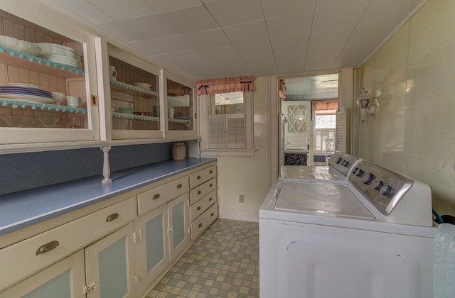 clothes washing area featuring baseboards, washing machine and clothes dryer, and tile patterned floors