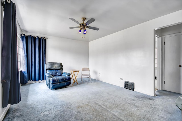 living area featuring ceiling fan, visible vents, and carpet flooring