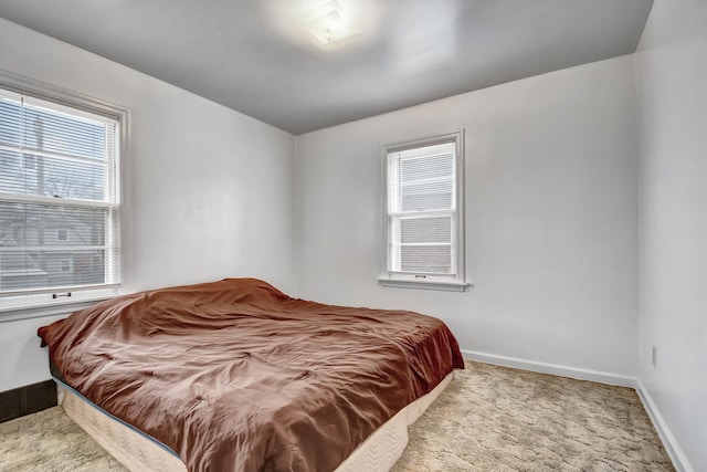 bedroom featuring carpet floors, multiple windows, and baseboards