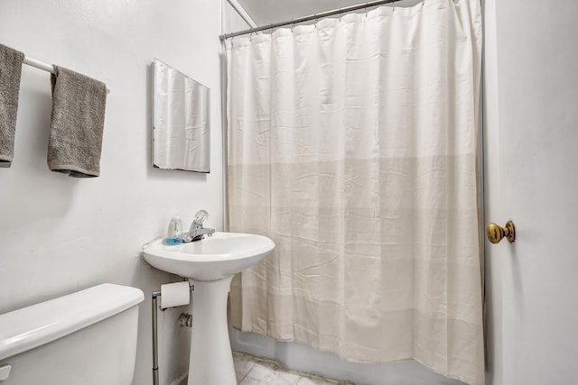 full bathroom with shower / tub combo, a sink, and toilet