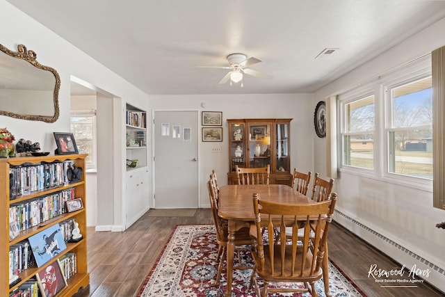 dining area with plenty of natural light, a baseboard radiator, and dark wood finished floors