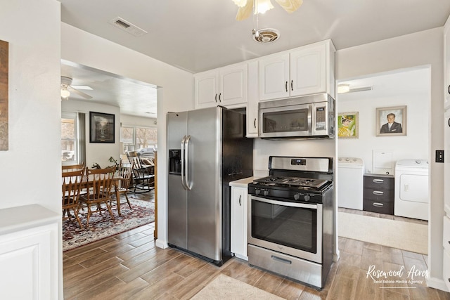 kitchen featuring visible vents, appliances with stainless steel finishes, wood finish floors, white cabinetry, and separate washer and dryer