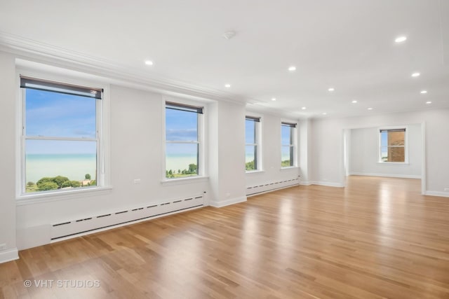 spare room with light wood-style flooring, a baseboard heating unit, baseboards, and recessed lighting