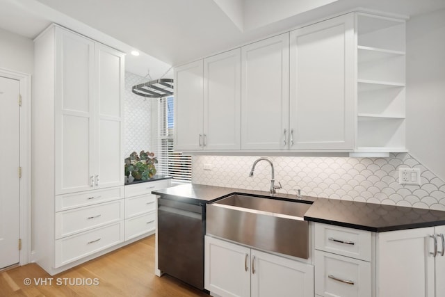 kitchen featuring dark countertops, white cabinetry, open shelves, and a sink