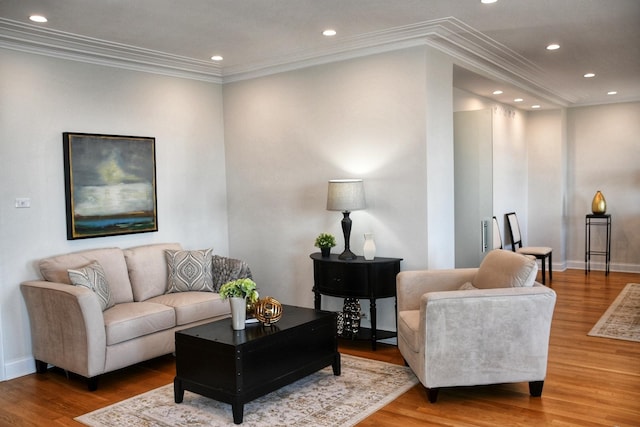 living area featuring baseboards, ornamental molding, wood finished floors, and recessed lighting