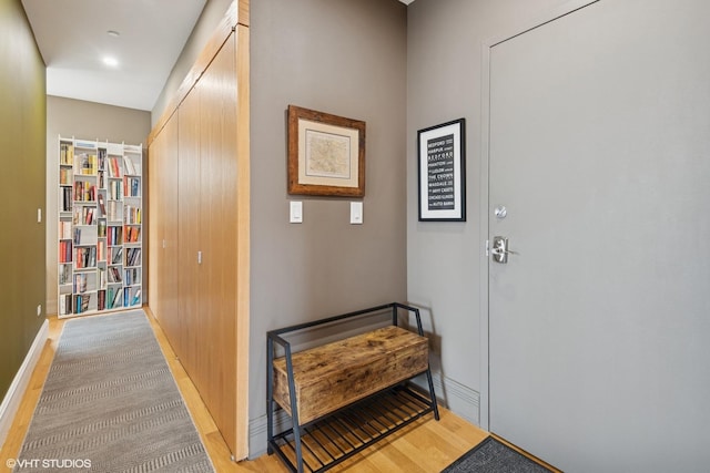 hall featuring light wood-type flooring and baseboards