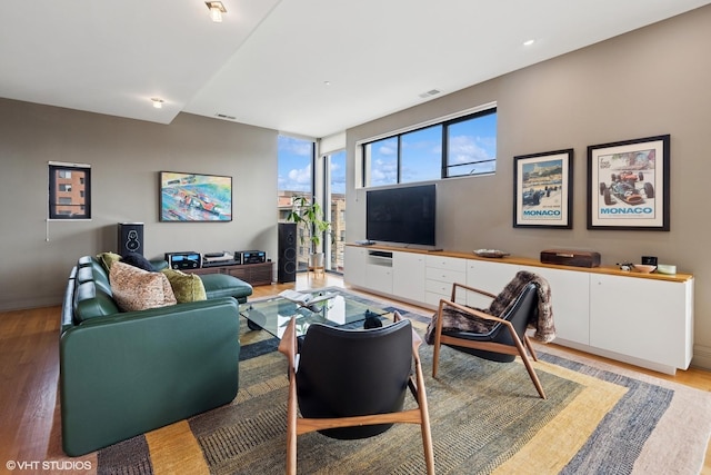 living area featuring light wood-type flooring, baseboards, and visible vents