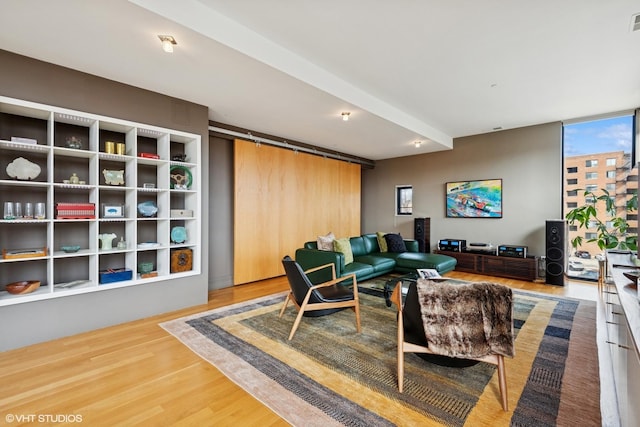 living room featuring expansive windows, a barn door, and wood finished floors