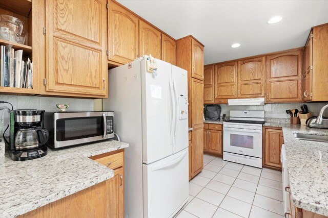 kitchen featuring light tile patterned flooring, a sink, white appliances, recessed lighting, and under cabinet range hood