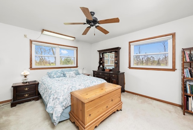 bedroom featuring a ceiling fan, baseboards, and light carpet