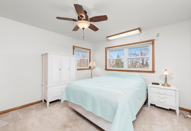 bedroom featuring baseboards, a ceiling fan, and light carpet