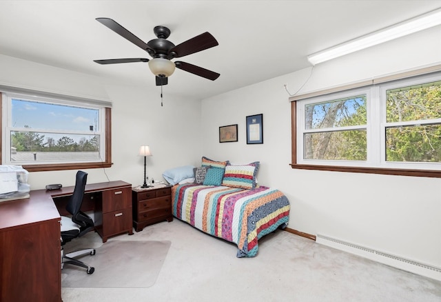 bedroom with multiple windows, a baseboard heating unit, ceiling fan, and light colored carpet