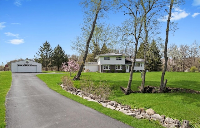 view of front facade featuring an outdoor structure, a garage, roof mounted solar panels, and a front yard