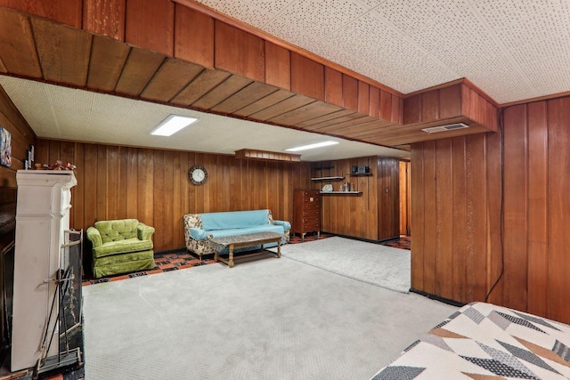 living area with wood walls, visible vents, and carpet flooring