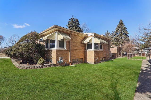 view of side of property with fence, a lawn, and brick siding