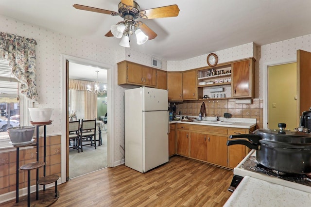 kitchen with open shelves, light countertops, visible vents, freestanding refrigerator, and wallpapered walls