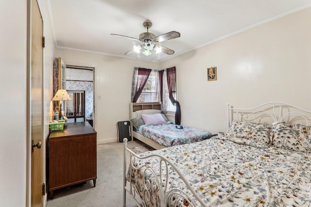 carpeted bedroom featuring crown molding, baseboards, and ceiling fan