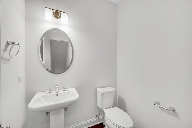 bathroom with toilet and baseboards