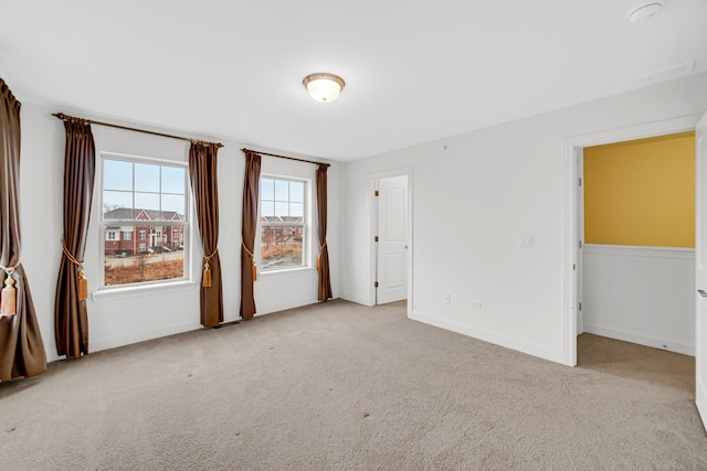 carpeted empty room with baseboards