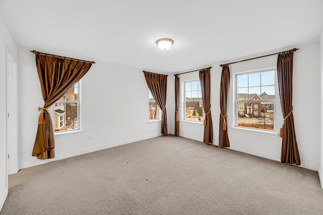 spare room with light carpet and baseboards