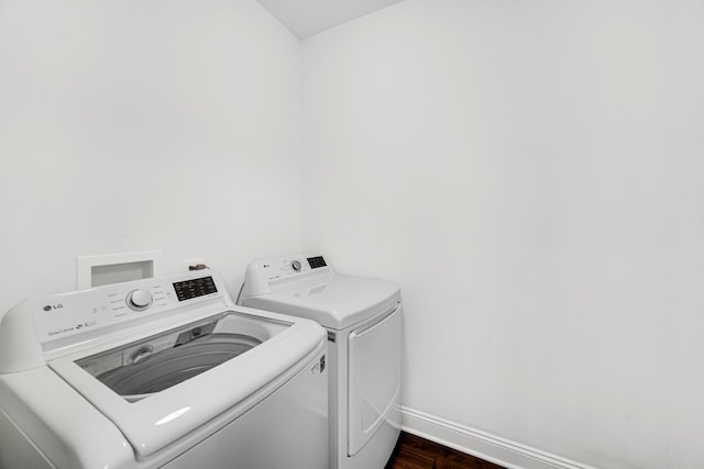 washroom with laundry area, baseboards, dark wood finished floors, and washing machine and clothes dryer