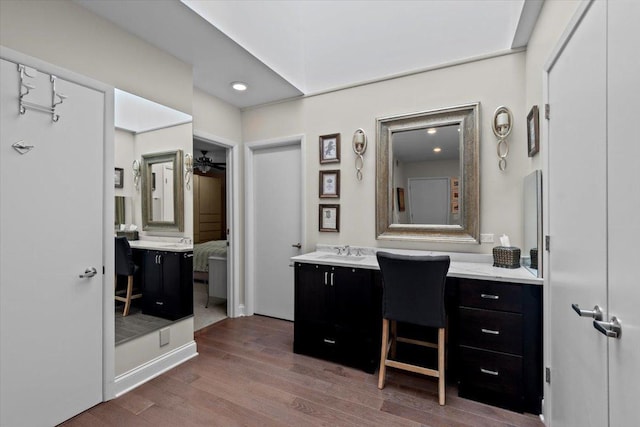 ensuite bathroom featuring ceiling fan, connected bathroom, vanity, and wood finished floors