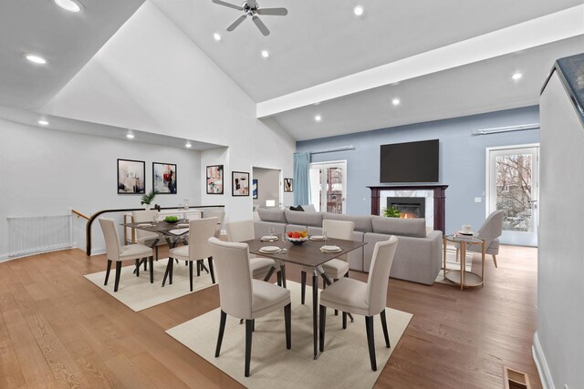 living room featuring a high ceiling, wood finished floors, a ceiling fan, and recessed lighting