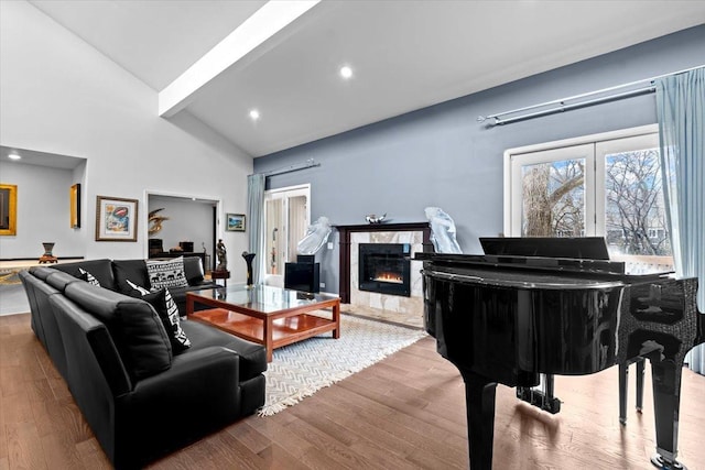 living area featuring a premium fireplace, wood finished floors, beamed ceiling, high vaulted ceiling, and recessed lighting