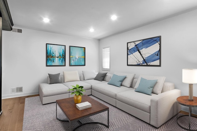 living room featuring recessed lighting, visible vents, wood finished floors, and ornamental molding