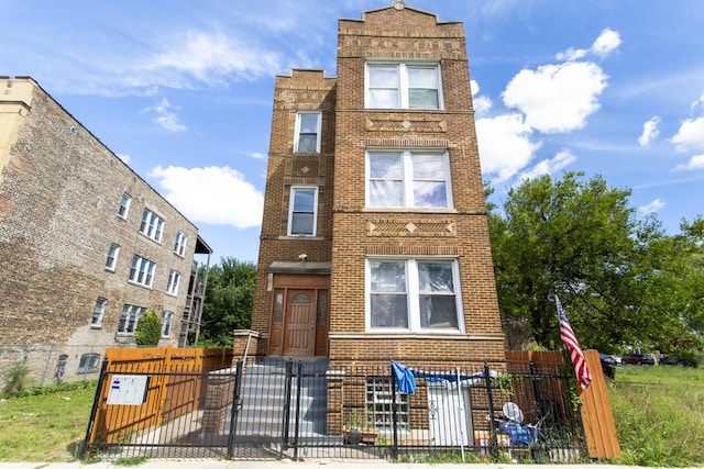 view of front of house with brick siding, a fenced front yard, and a gate