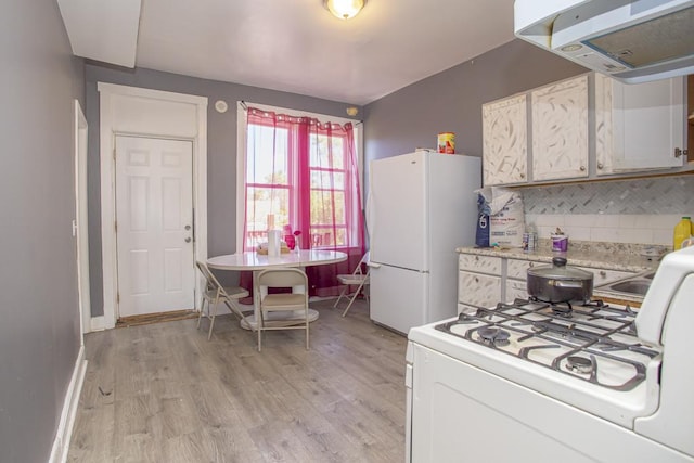 kitchen featuring white appliances, tasteful backsplash, range hood, light countertops, and light wood-type flooring