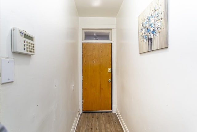 doorway to outside with baseboards and wood finished floors