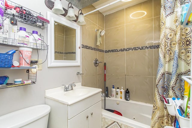 full bath featuring tiled shower / bath, vanity, and toilet