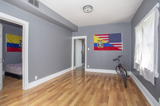 interior space with baseboards, visible vents, and light wood finished floors