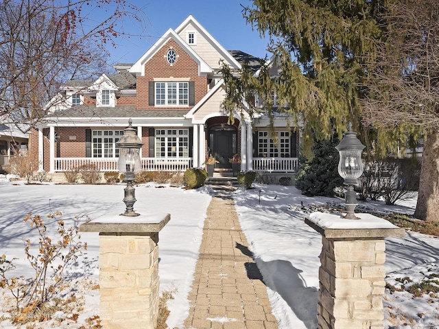 view of front of home with covered porch and brick siding