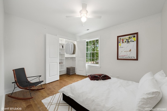 bedroom featuring a closet, wood finished floors, visible vents, and a ceiling fan