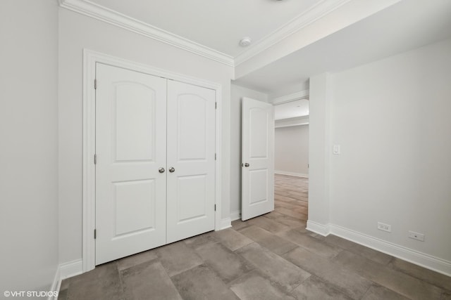 unfurnished bedroom with a closet, baseboards, and crown molding