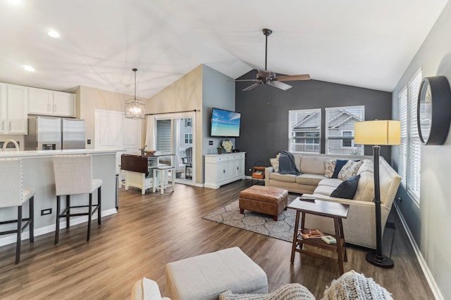 living area with vaulted ceiling, baseboards, dark wood finished floors, and ceiling fan with notable chandelier