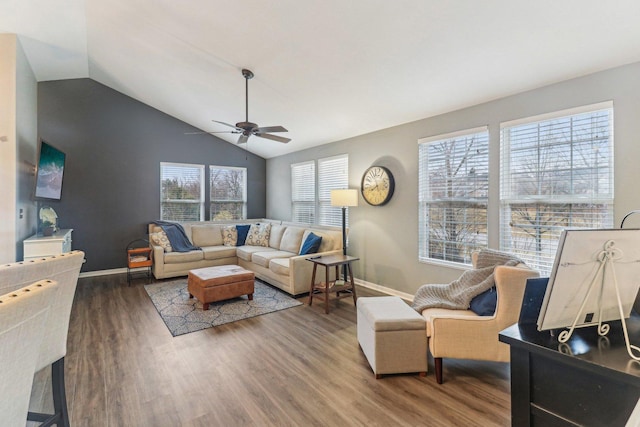 living area featuring lofted ceiling, plenty of natural light, baseboards, and wood finished floors