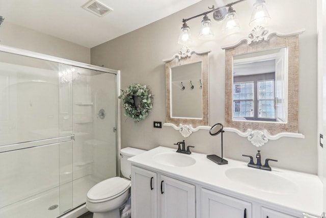 bathroom with a stall shower, visible vents, and a sink